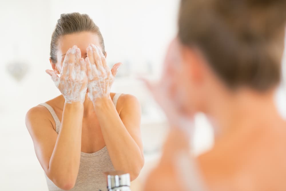 mujer de piel grasa lavando su rostro